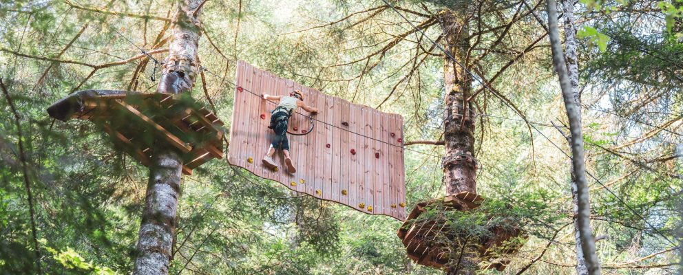 Adulte sur le mur d'escalade rouge de l'AccroTyro des Géants