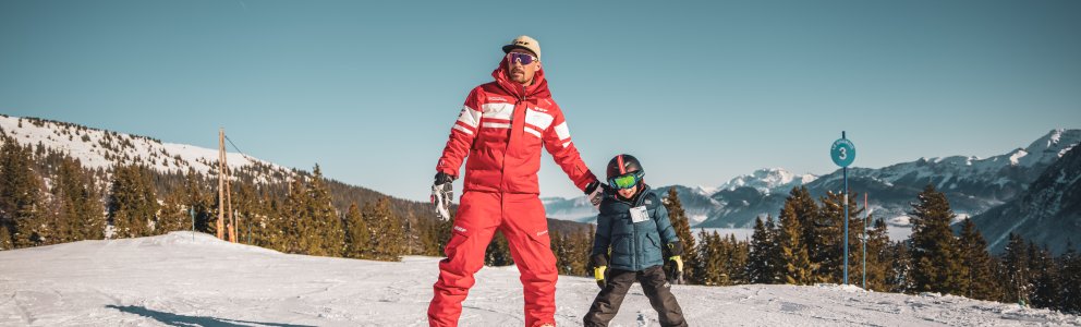 Moniteur de ski avec petit enfant en chasse neige