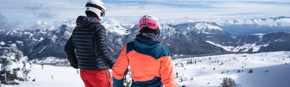 Jeunes adultes skieurs debout devant le paysage