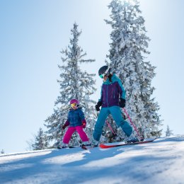 Mère avec son enfant en bas âge qui skient