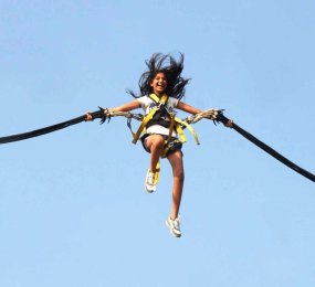 Femme dans le ciel  sautant en Bungee Ejection, attachée à deux élastiques