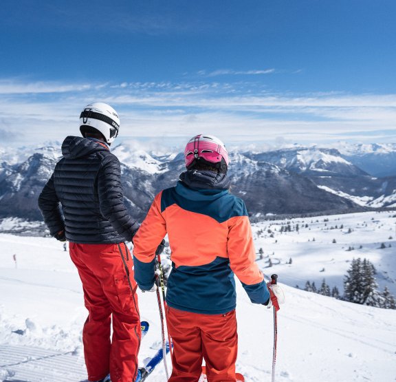 Jeunes adultes skieurs debout devant le paysage