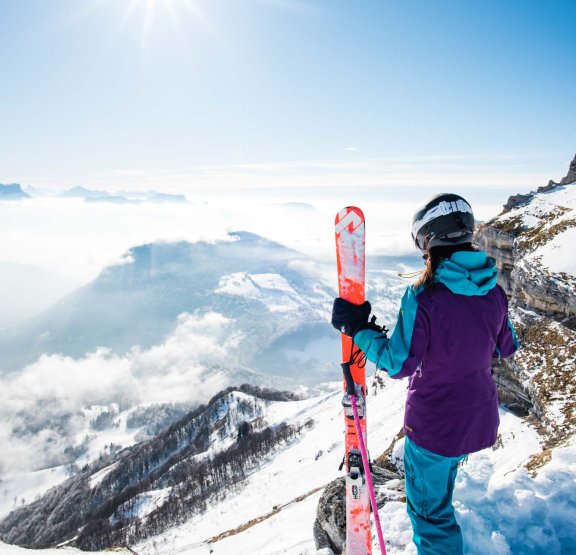 Skieuse avec ski à la main devant paysage