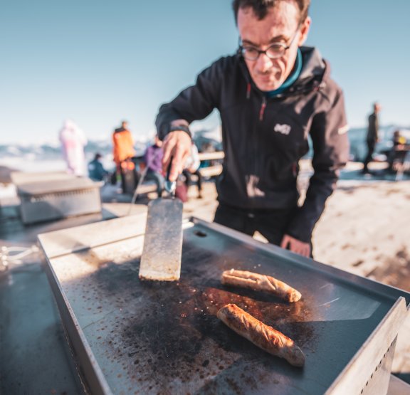 Skieur en train de cuisiner sur la plancha