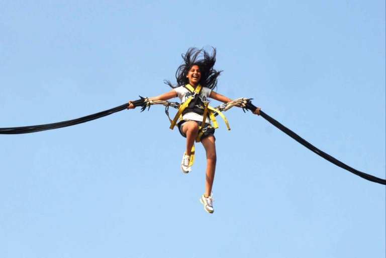 Femme dans le ciel  sautant en Bungee Ejection, attachée à deux élastiques