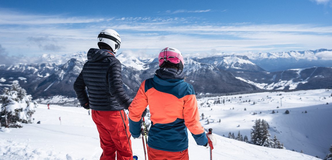 Jeunes adultes skieurs debout devant le paysage